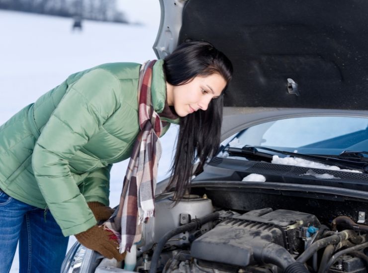 Ragazza alle prese con il motore della sua automobile