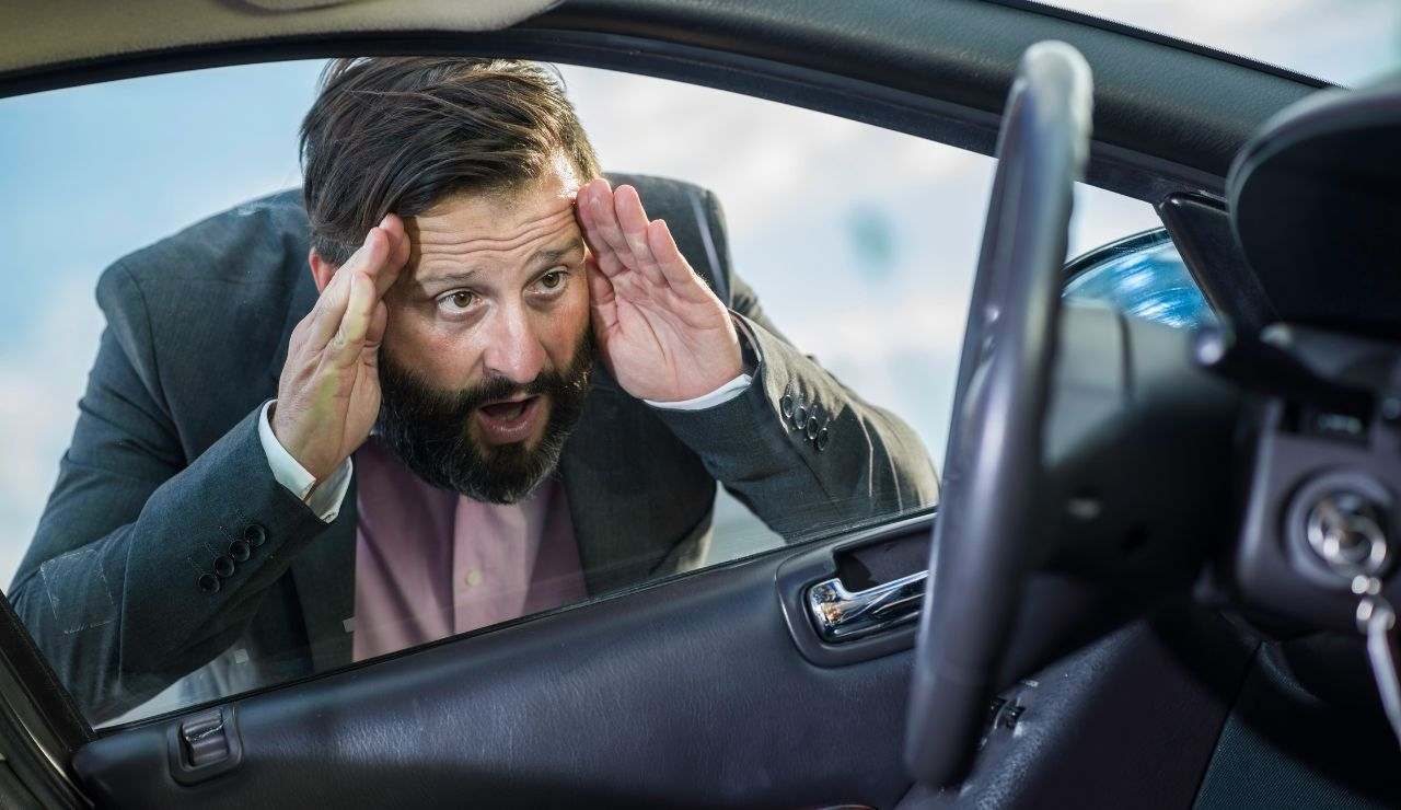 Uomo con faccia al finestrino dell'auto ed espressione disperata